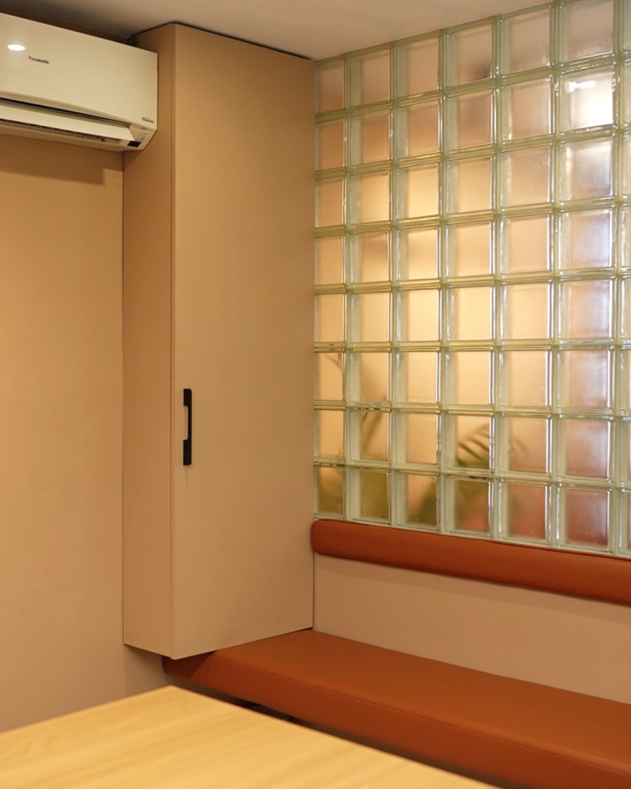 Sabu CS & Company — Glass-block partition detail and tan banquette bench
