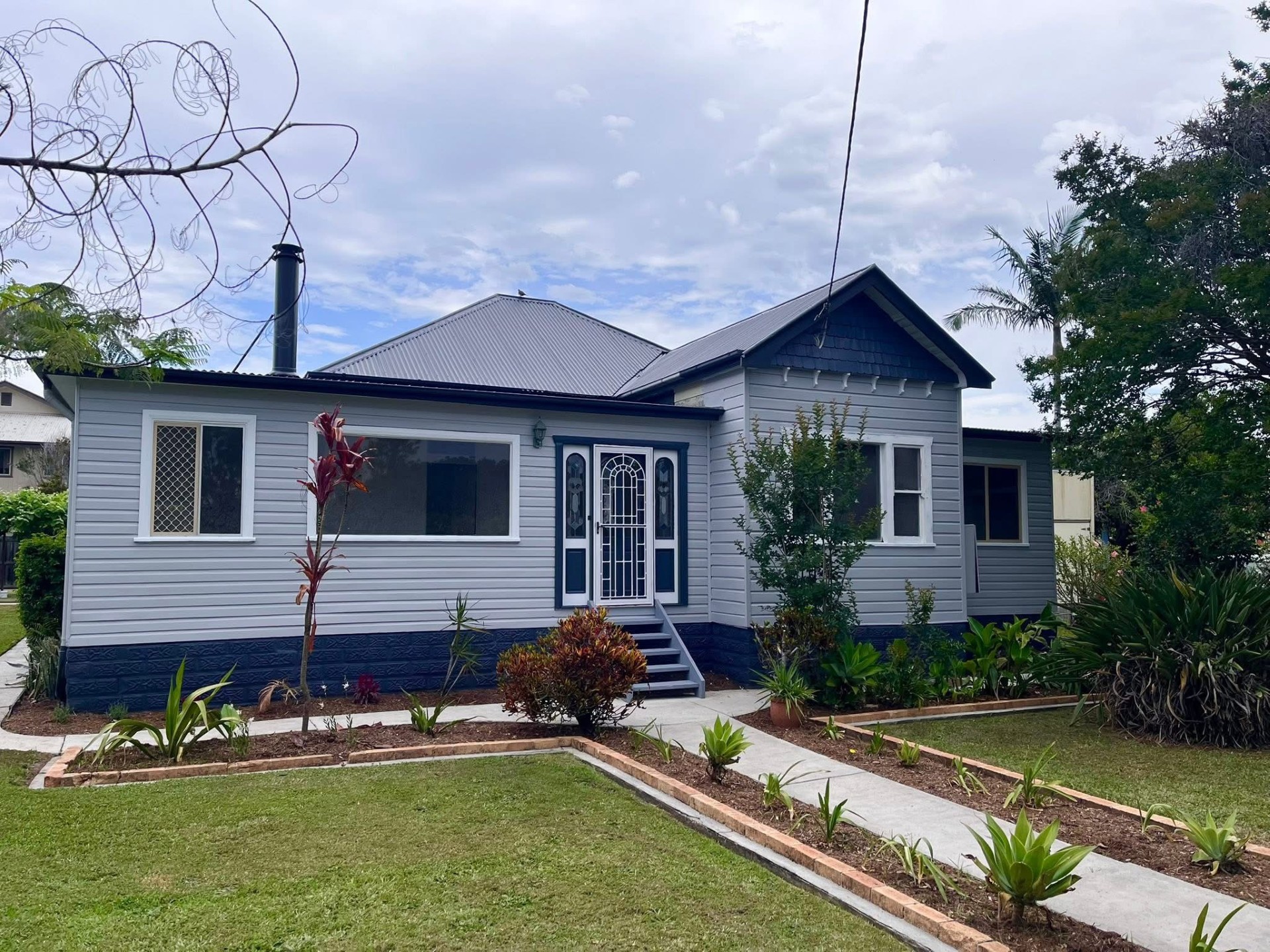 Weatherboard cottage freshly painted grey and navy by After Paint