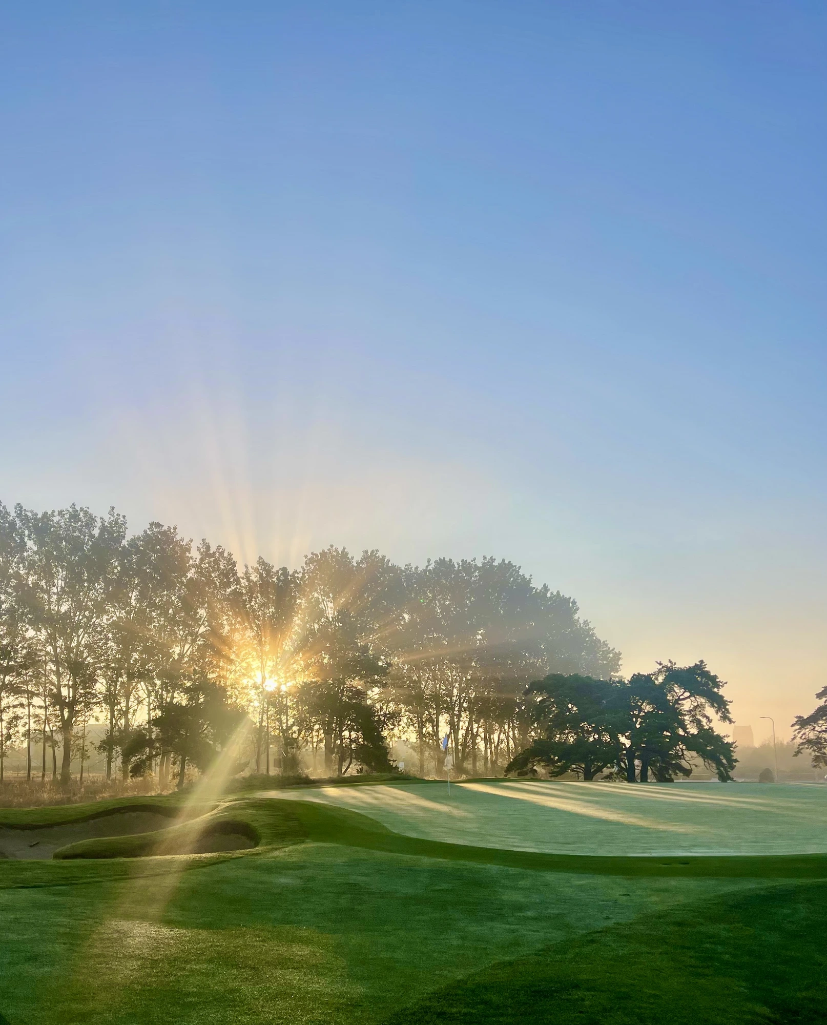 Aerial view of a lush golf course at sunrise