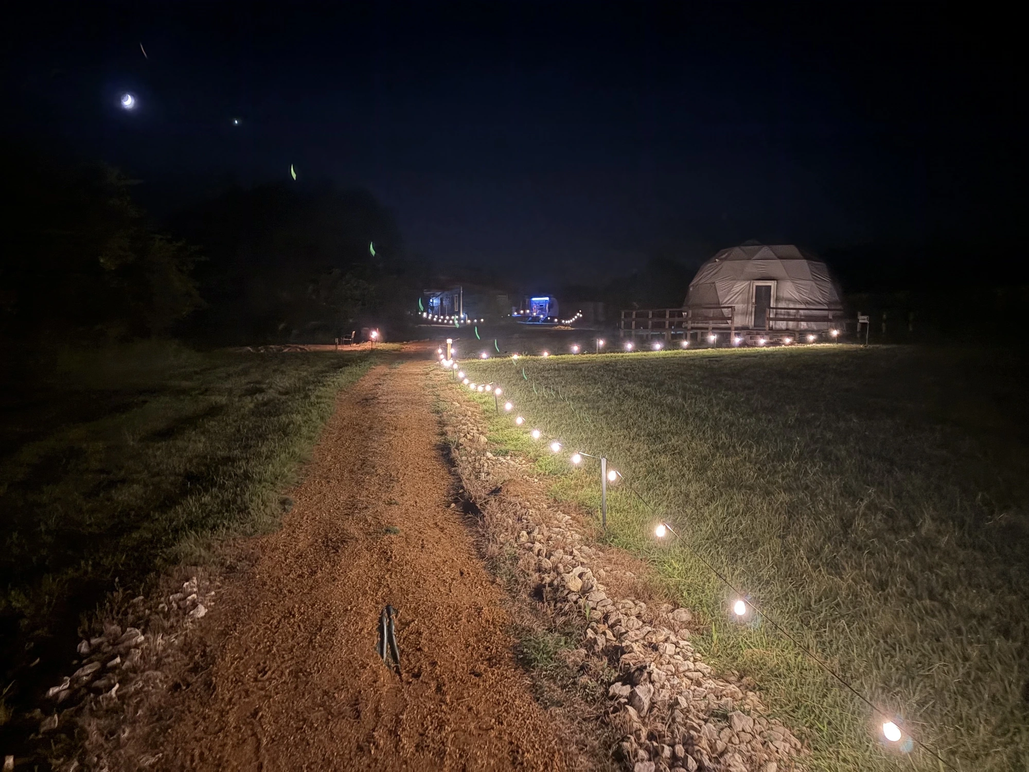 Lighted pathway to the glamping domes at night