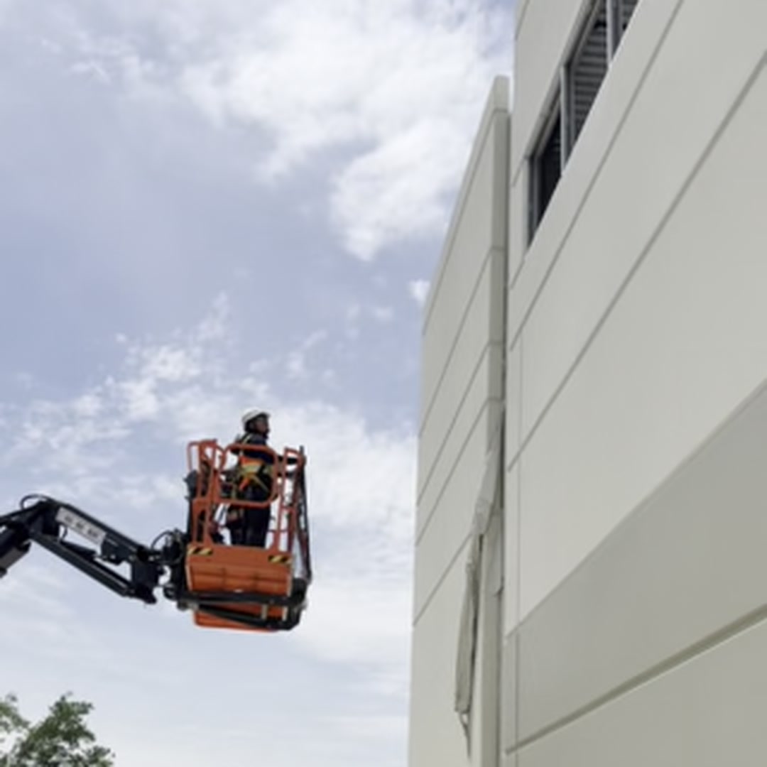 Highwall Lift-Hanger - boom lift positioned at building exterior for panel work