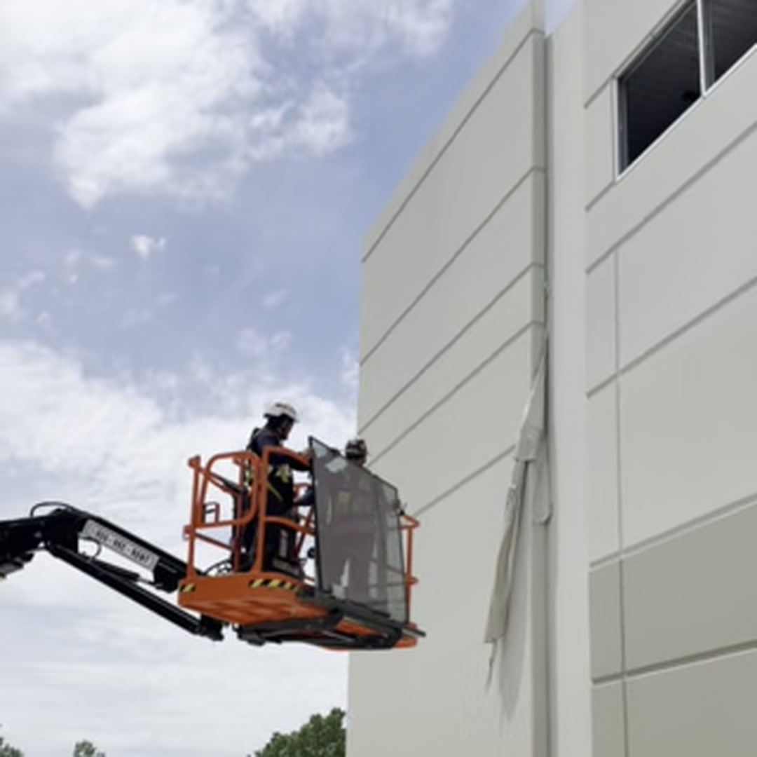 Highwall Lift-Hanger in use - two crew members positioning panel from boom lift basket